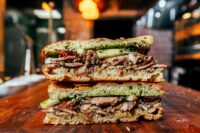 signature porchetta sandwich is a labor of love, prepared out of a deboned whole local pig, rubbed with traditional aromatics: rosemary, fennel, garlic, and black pepper,” chef/owner Michael Toscano said. (Photo/Walker Creative Inc.)
